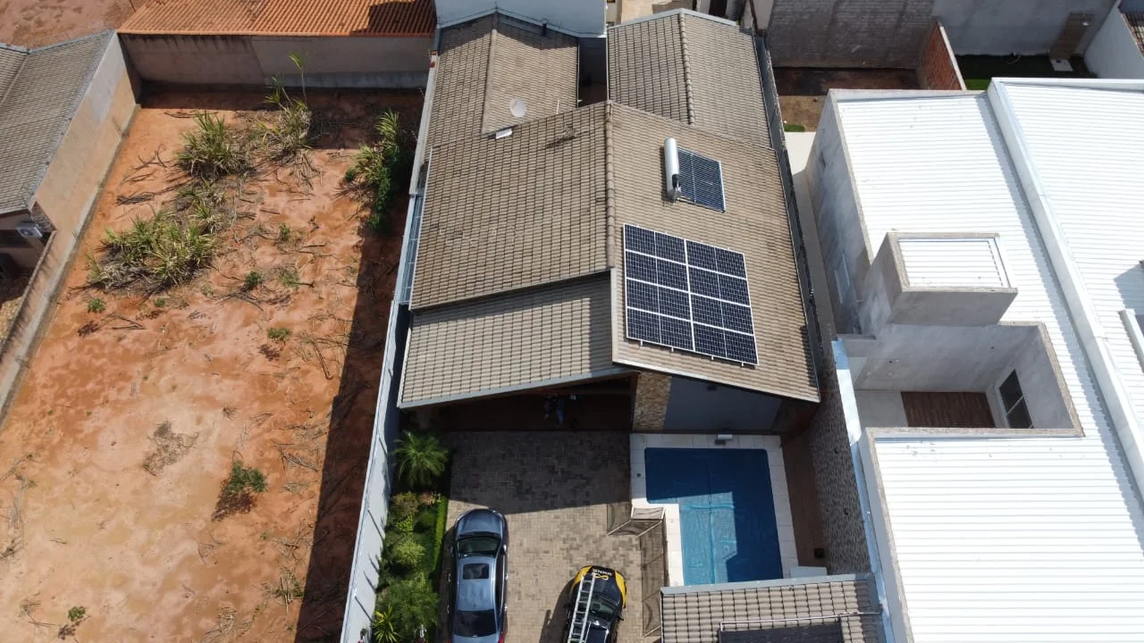 Vista aérea de uma casa com painéis solares no telhado.
